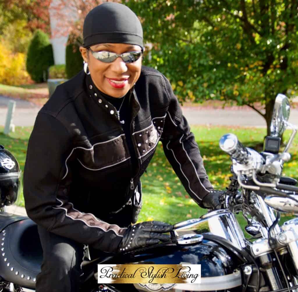 Kimberly R Jones sitting on her Harley Davidson motorcycle leaning forward.