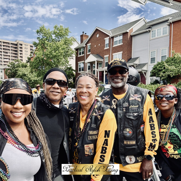 This image captures a vibrant group from the National Association of Buffalo Soldiers & Troopers Motorcycle Club (NABSTMC) posing together outdoors.