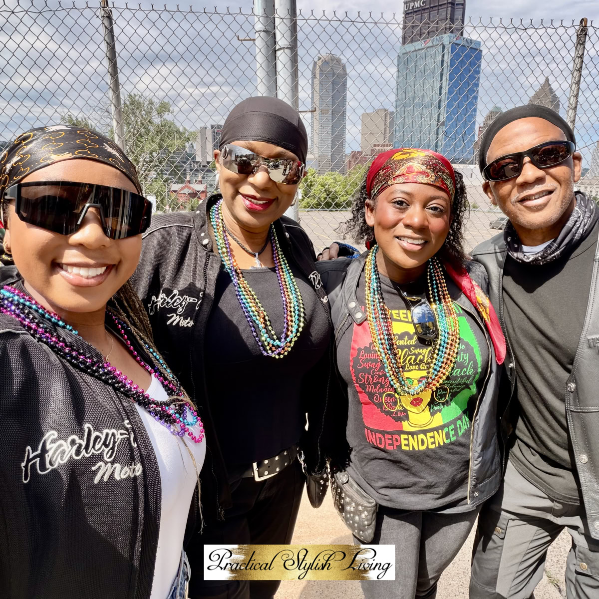 A group of motorcycle riders enjoying a sunny day outdoors, featuring two people prominently wearing branded Harley-Davidson Moto jackets and colorful beaded necklaces.
