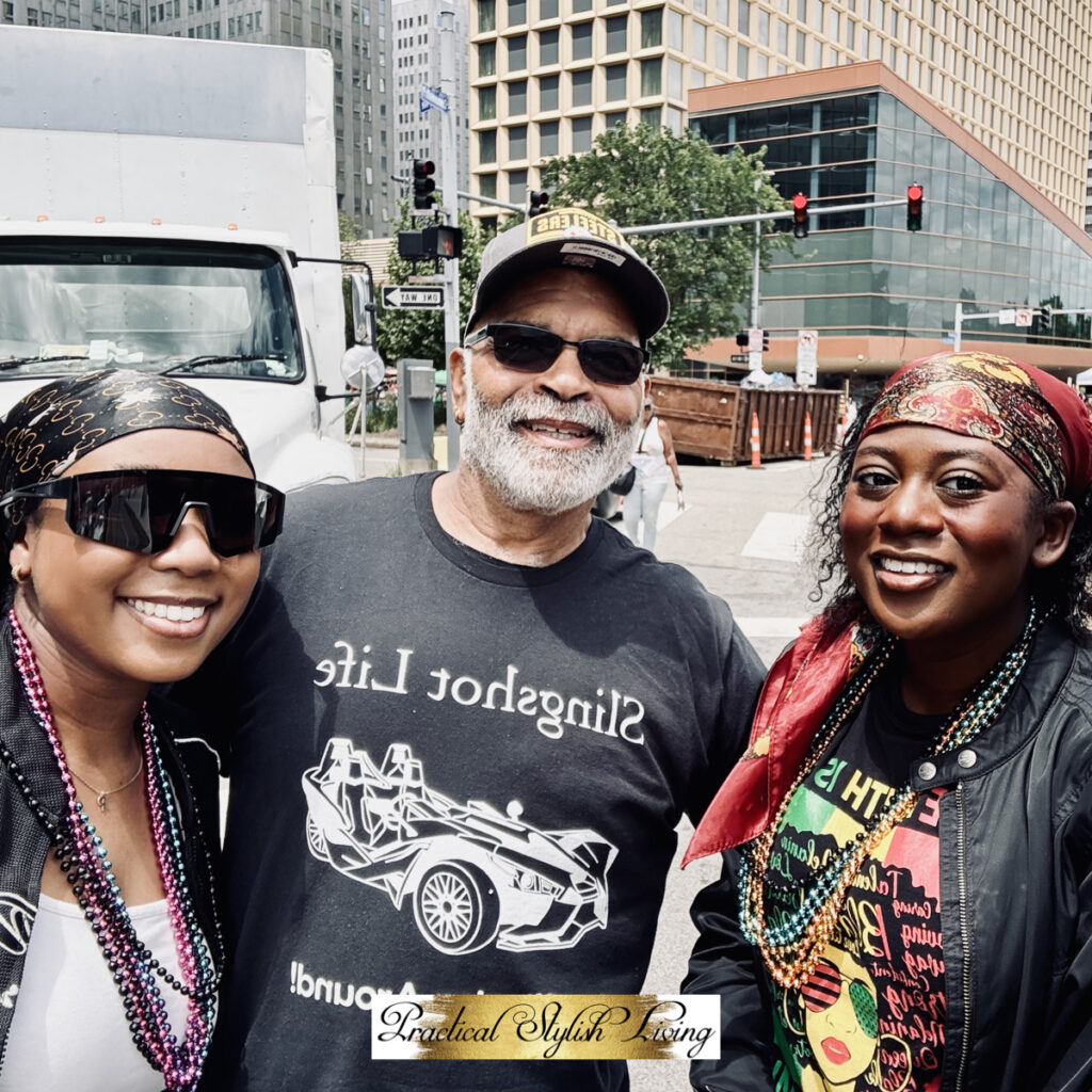 Three men and women smiling together during an outdoor cultural event.
